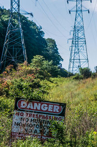 Information sign on electricity pylon against sky