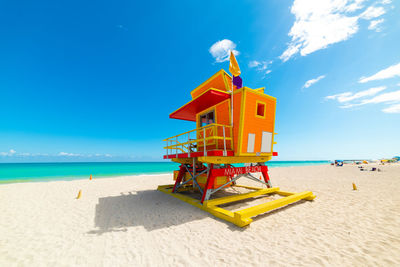 Lifeguard hut on beach against sky