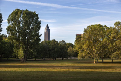 Trees in park by city against sky