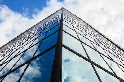 Low angle view of office building against cloudy sky