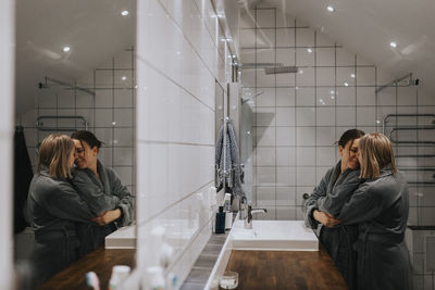 Female homosexual couple hugging in bathroom