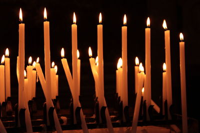 Close-up of lit candles in darkroom