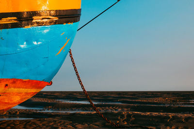 Boat moored on sea against clear sky