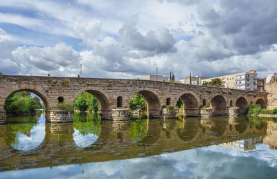 Arch bridge over river against sky