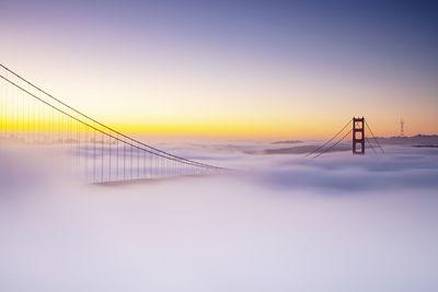 View of suspension golden gate bridge against sky during sunset