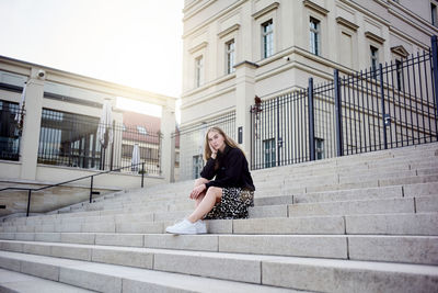 Portrait of woman sitting on staircase