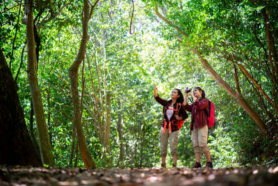 Full length of a woman standing in forest