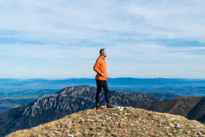 Full length of man standing on rock against sky