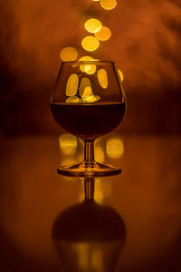 Close-up of illuminated wine glass on table