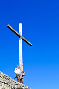 Low angle view of cross against clear blue sky