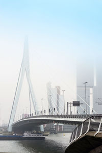 Bridge over river in city against clear sky