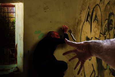 Midsection of man holding woman against wall