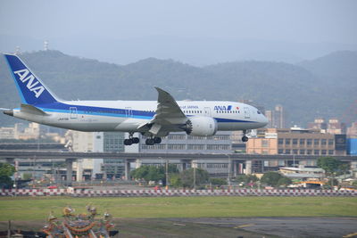 Airplane on airport runway against sky