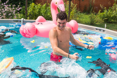 Full length of shirtless man in swimming pool