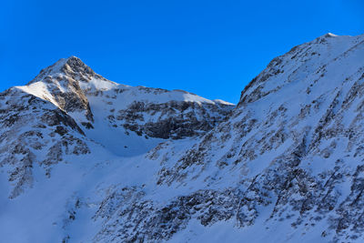 Scenic view of snowcapped mountains against clear blue sky