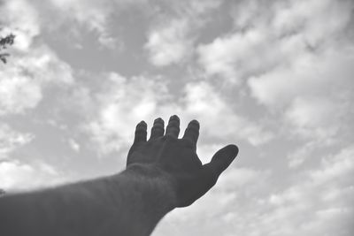Cropped hand of man reaching sky