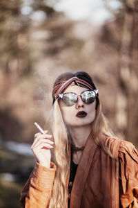 Young woman wearing sunglasses while standing outdoors