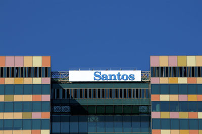 Low angle view of text on building against clear blue sky