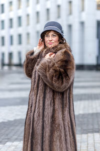 Portrait of young woman standing in city