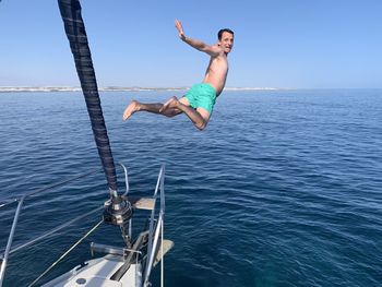 Rear view of man jumping in sea