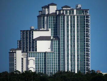 Low angle view of modern buildings against blue sky