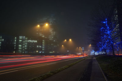 Light trails on road against sky at night