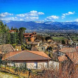 Houses in town against cloudy sky