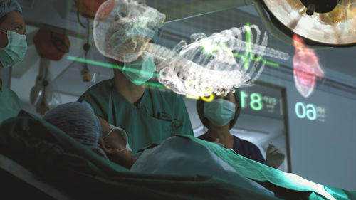 A surgeon diagnose a woman's heart problem via a holographic body scan before surgical procedure