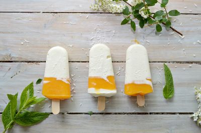 Close-up of popsicles with herbs on wooden table