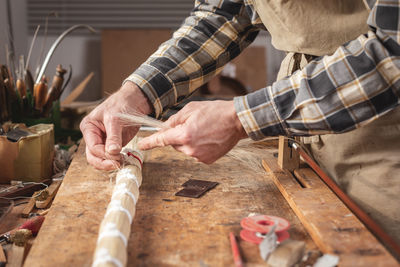 Midsection of man working on table