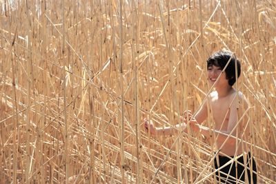 Shirtless boy standing by built structure