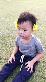 Portrait of boy sitting on field