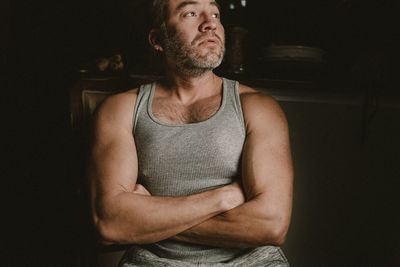 Full length of young man standing against black background