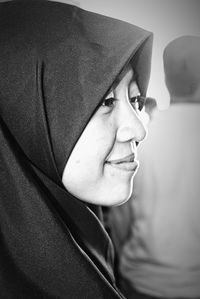 Close-up of smiling woman wearing hijab looking away