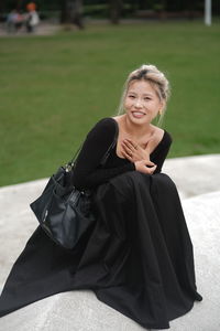 Portrait of young woman standing against wall