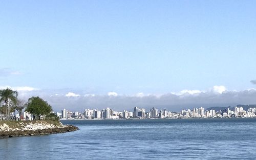 Scenic view of sea by buildings against sky