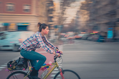 Rear view of man riding bicycle on street