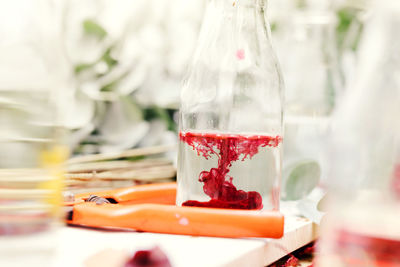 Close-up of red ink dissolving in water on table