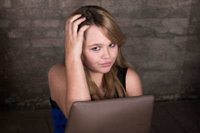 Portrait of teenage girl sitting on wall