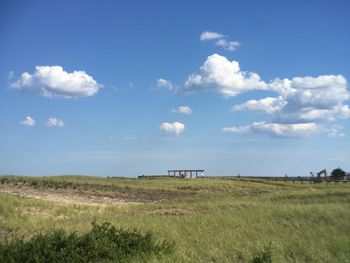 Scenic view of grassy field against cloudy sky