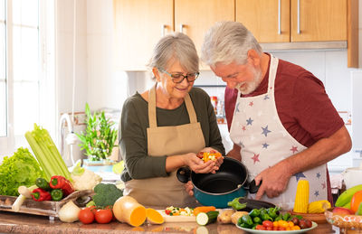 Man and woman standing by fruits