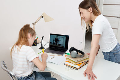 Mother helping daughter with homework