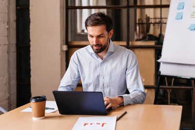 Young man using laptop at office