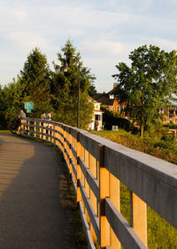 Footpath amidst buildings in city against sky