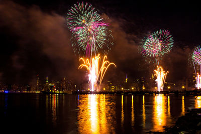 Firework display over river at night