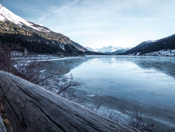 Scenic view of lake by snowcapped mountains against sky