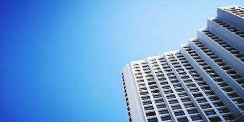 Low angle view of modern buildings against clear blue sky