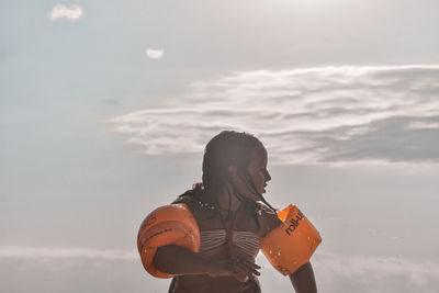 Full length of woman standing against sky