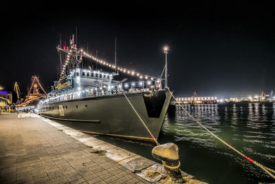Illuminated military ship in the sea at night