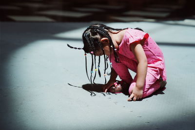 Girl with braided hair kneeling on floor